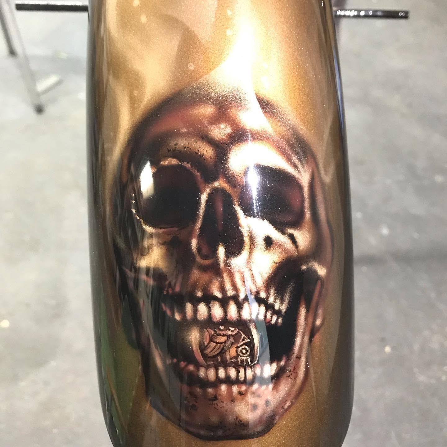 Ryan's Chopper — front fender closeup, skull with coin in mouth on gold metallic