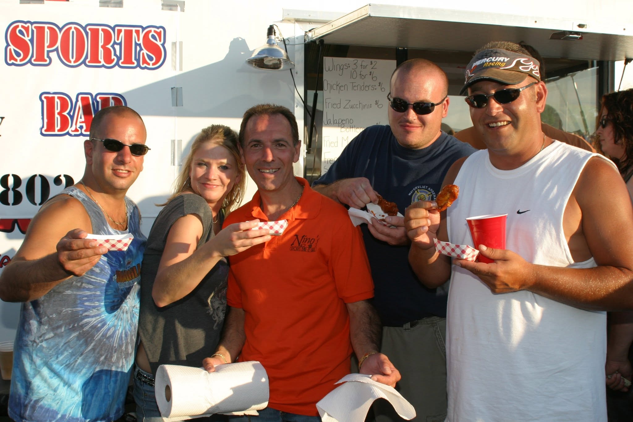 2006 Chick-N-Wing Festival — group of five friends eating wings at Nino's Sports Bar vendor booth