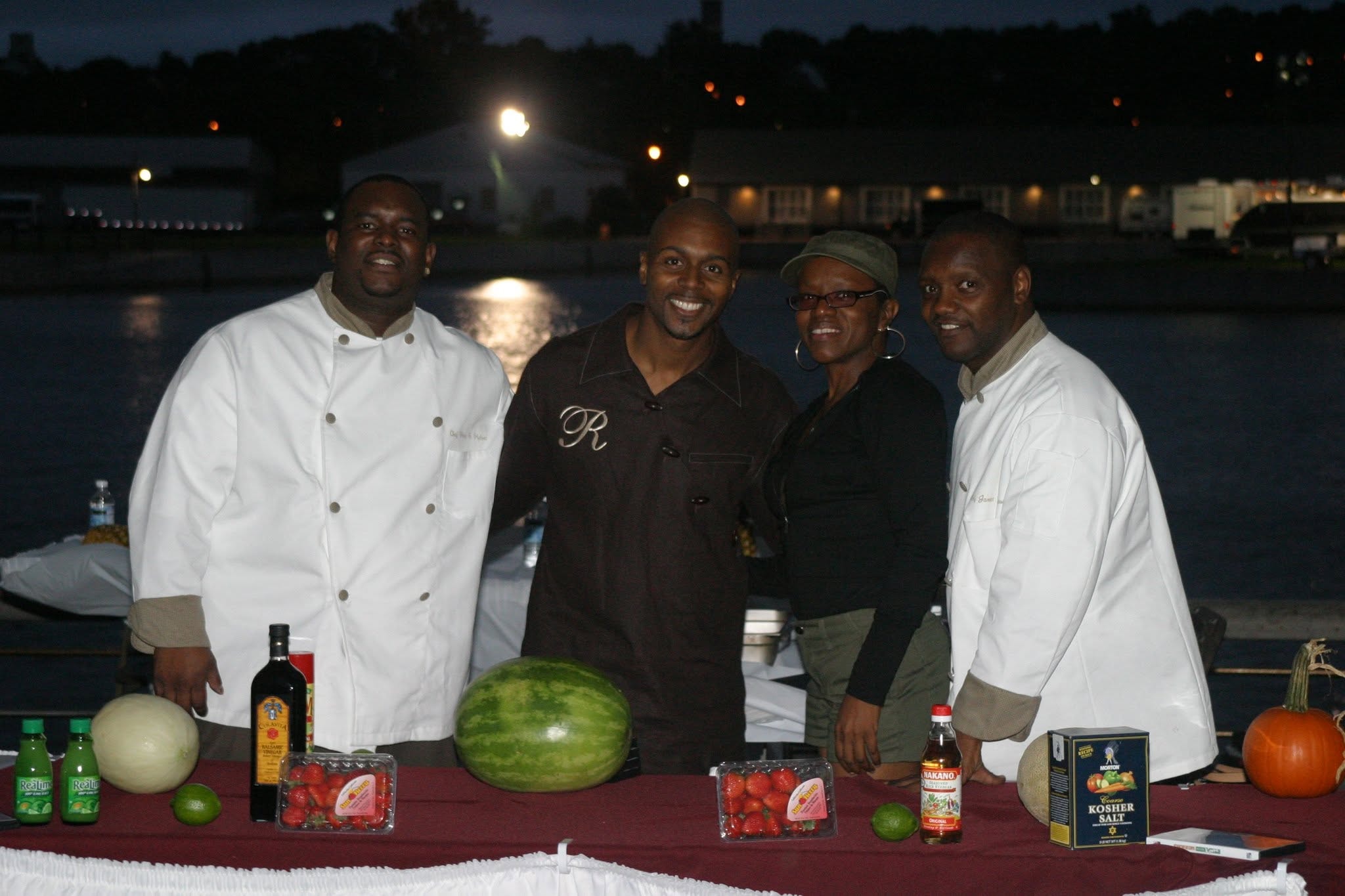 2006 Chick-N-Wing Festival — cooking show team of four chefs posing at waterfront demo table at night