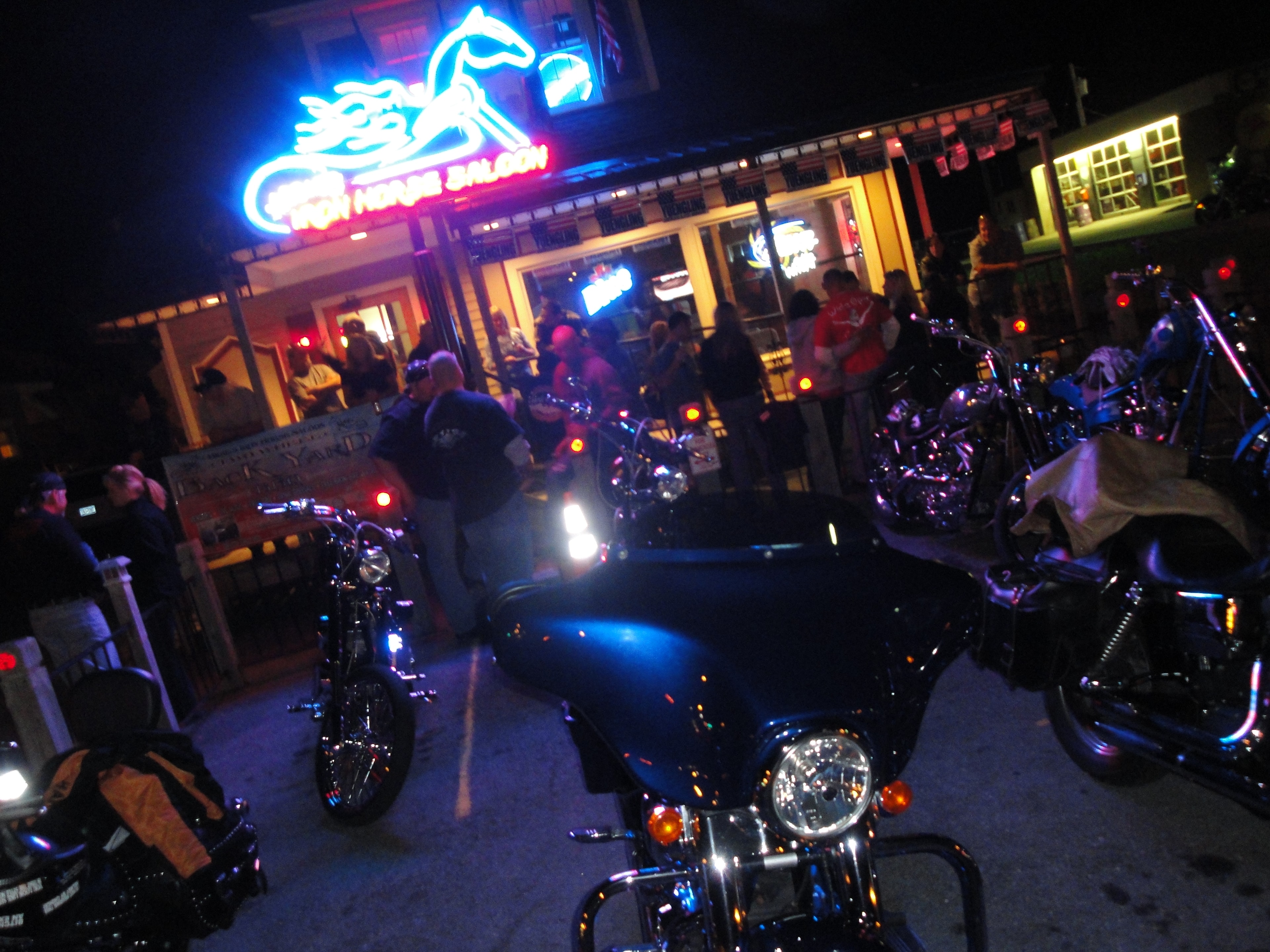 Higie's Iron Horse Saloon Summer BBQ Series — motorcycles parked outside the Iron Horse Saloon neon sign at night