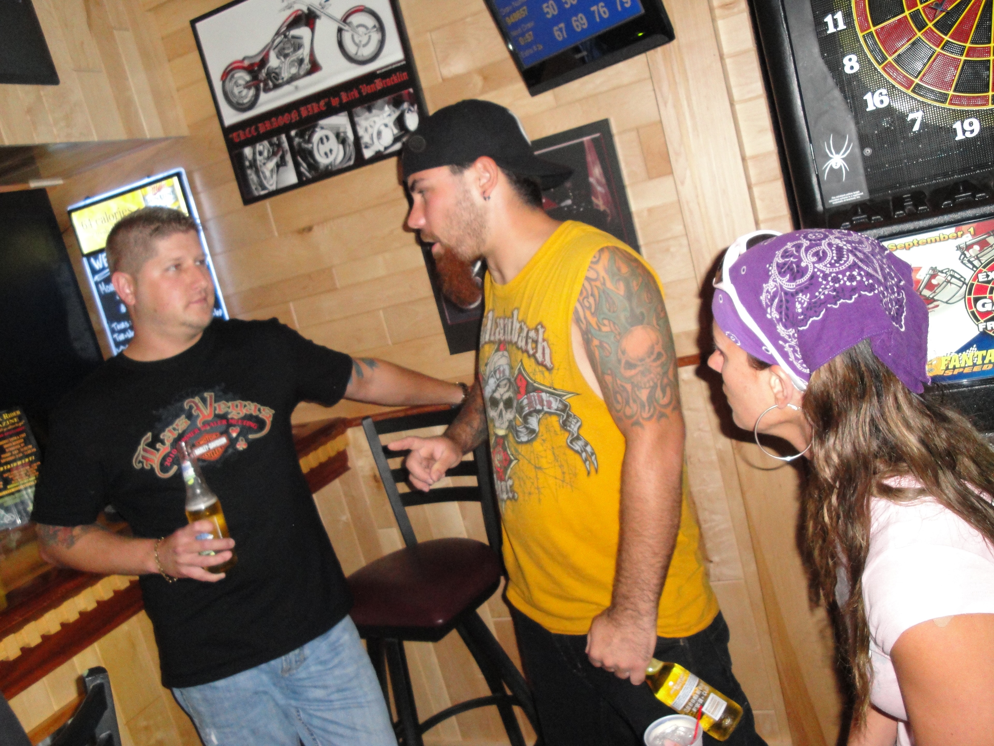 Higie's Iron Horse Saloon Summer BBQ Series — three people chatting inside the saloon near dart board