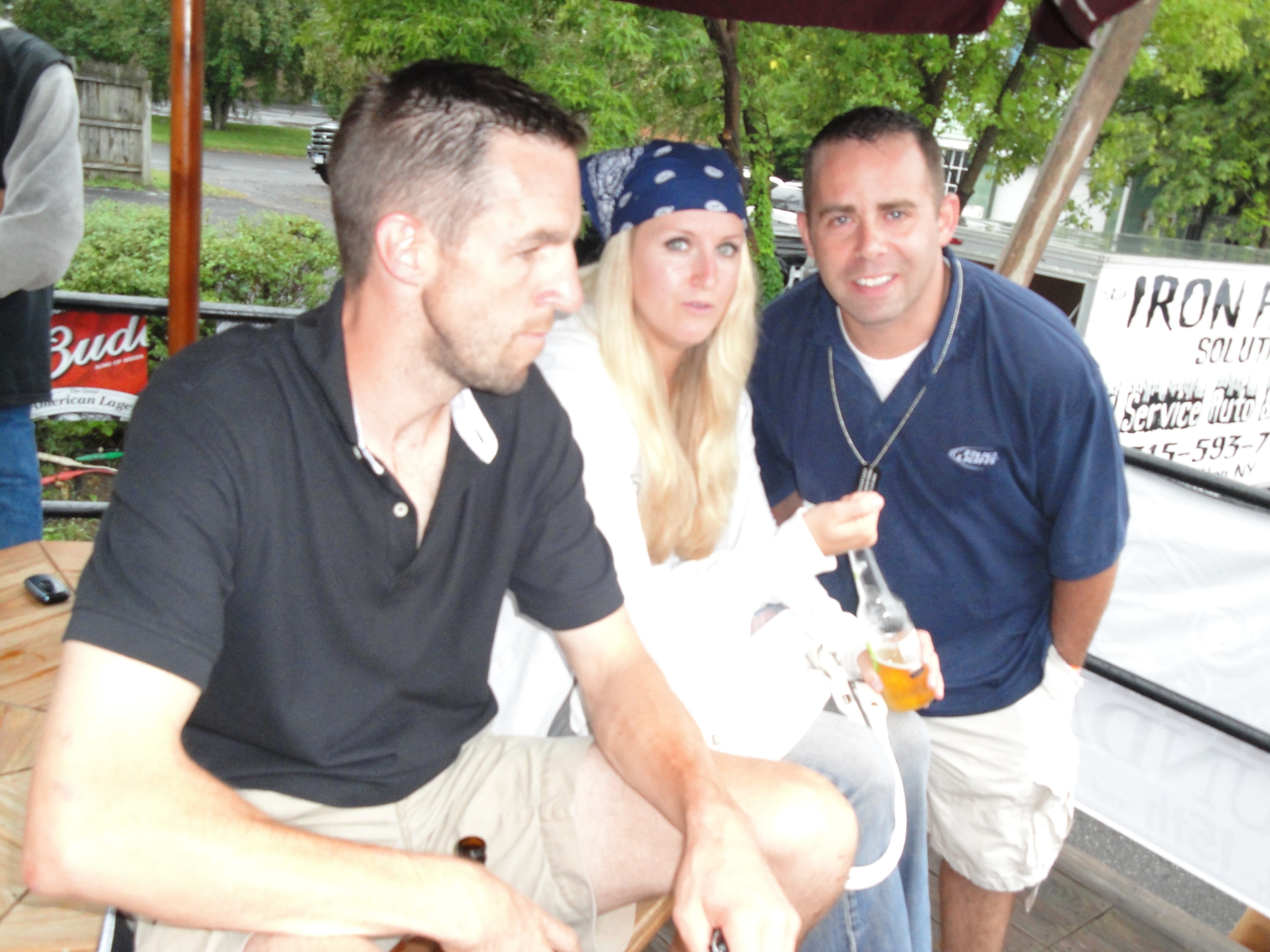 Higie's Iron Horse Saloon Summer BBQ Series — three people seated under Bud umbrella with Iron Horse sign