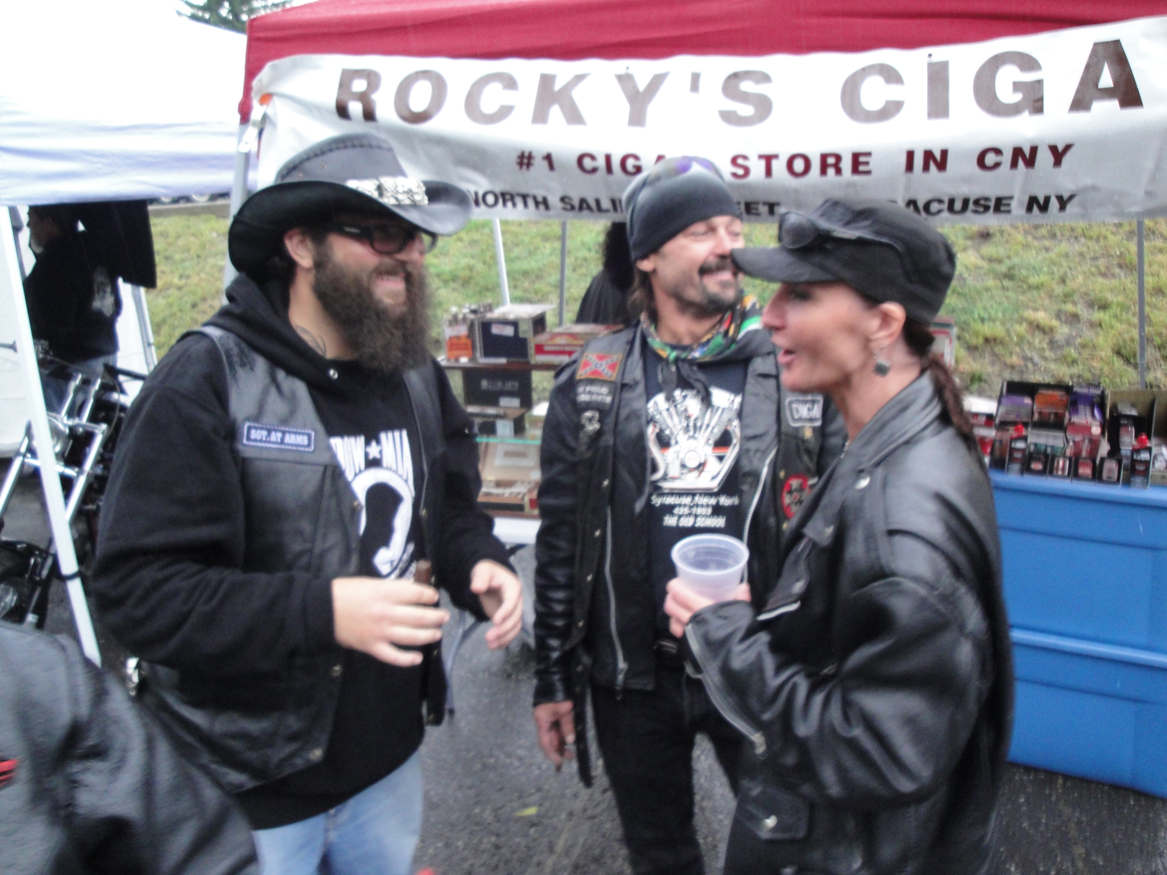 Higie's Iron Horse Saloon Summer BBQ Series — three people chatting near Rocky's Cigars tent at the event