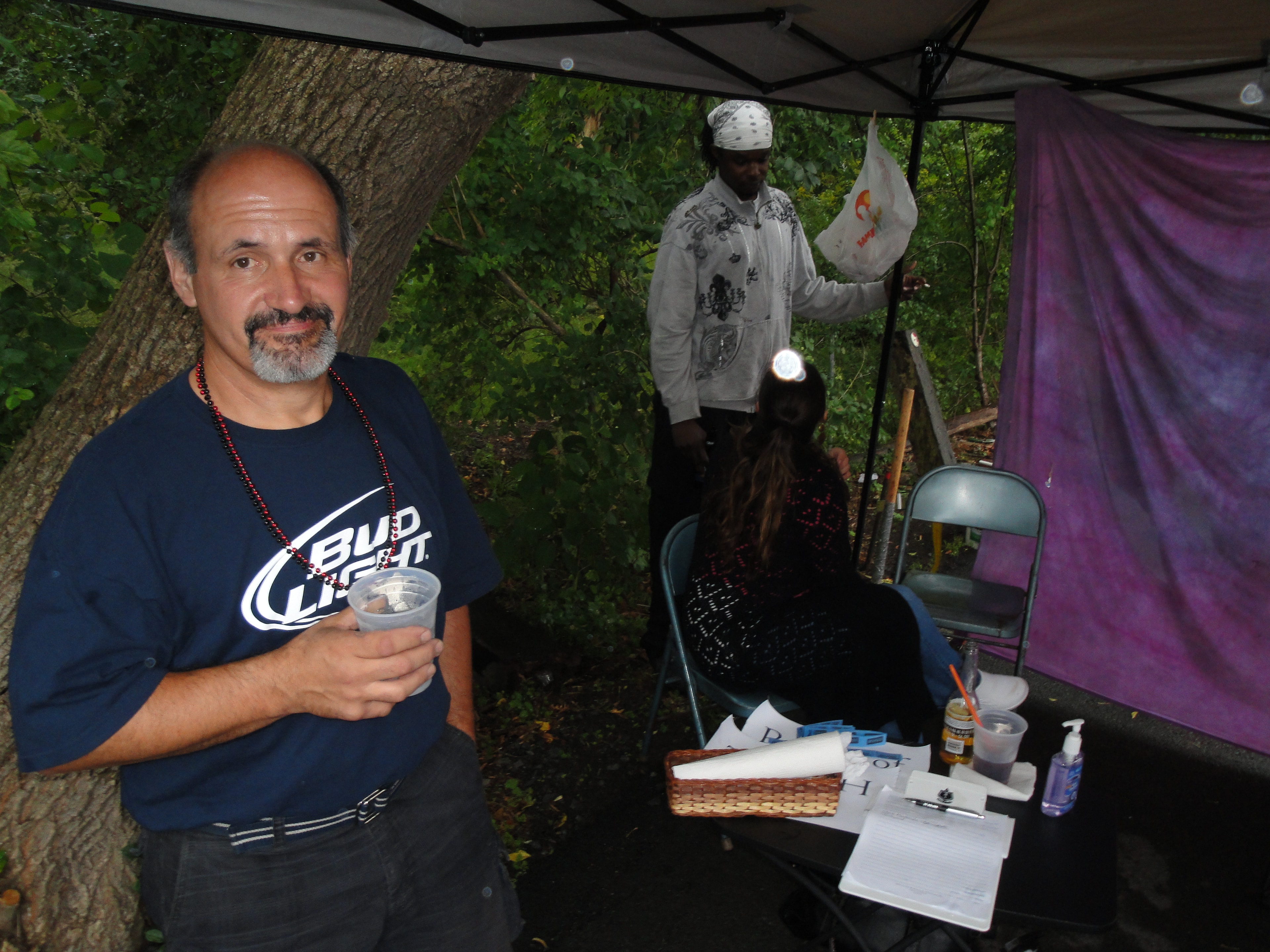 Higie's Iron Horse Saloon Summer BBQ Series — man in Bud Light shirt near henna tattoo tent at outdoor event
