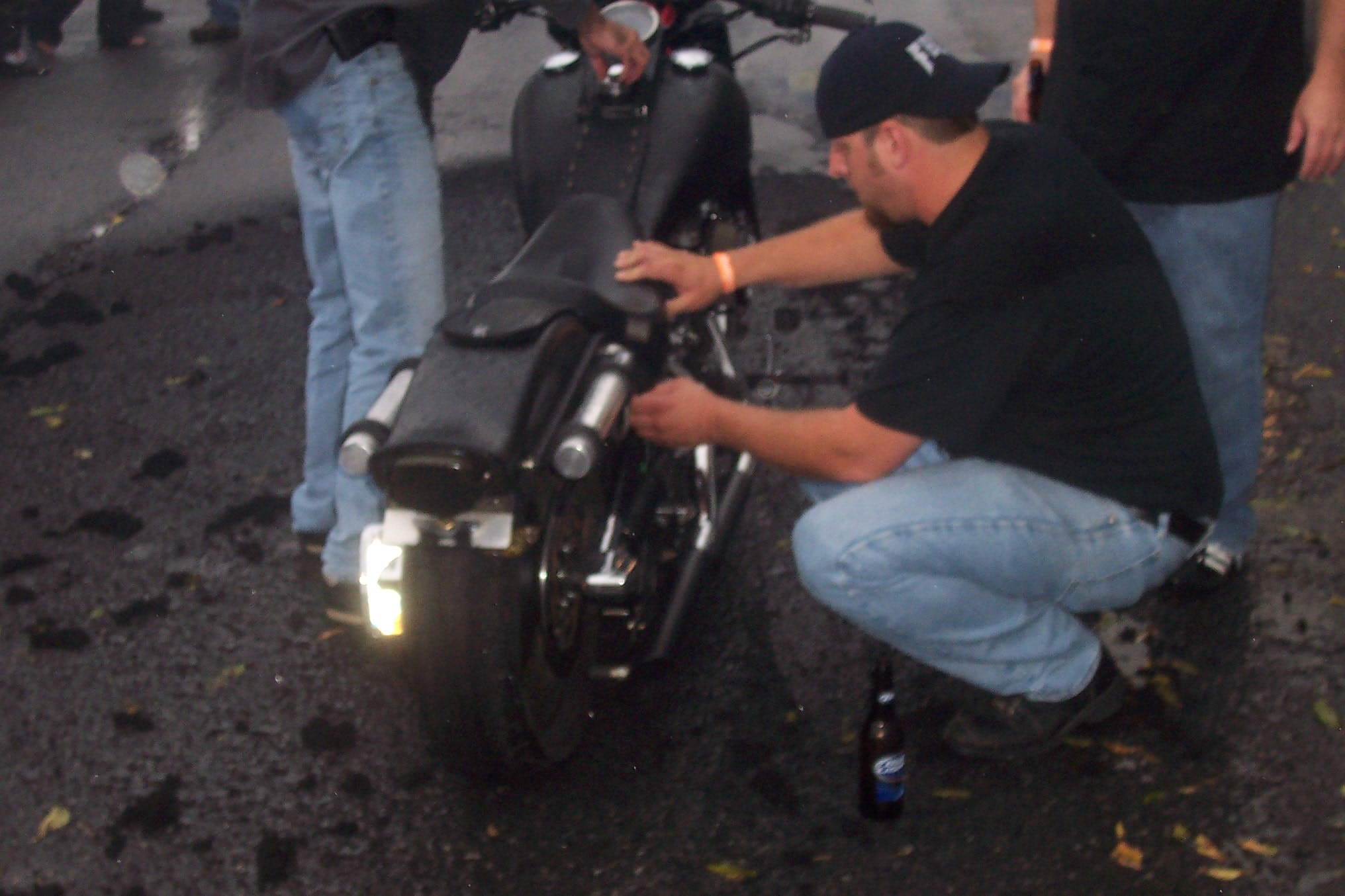 Higie's Iron Horse Saloon Summer BBQ Series — man inspecting motorcycle at night