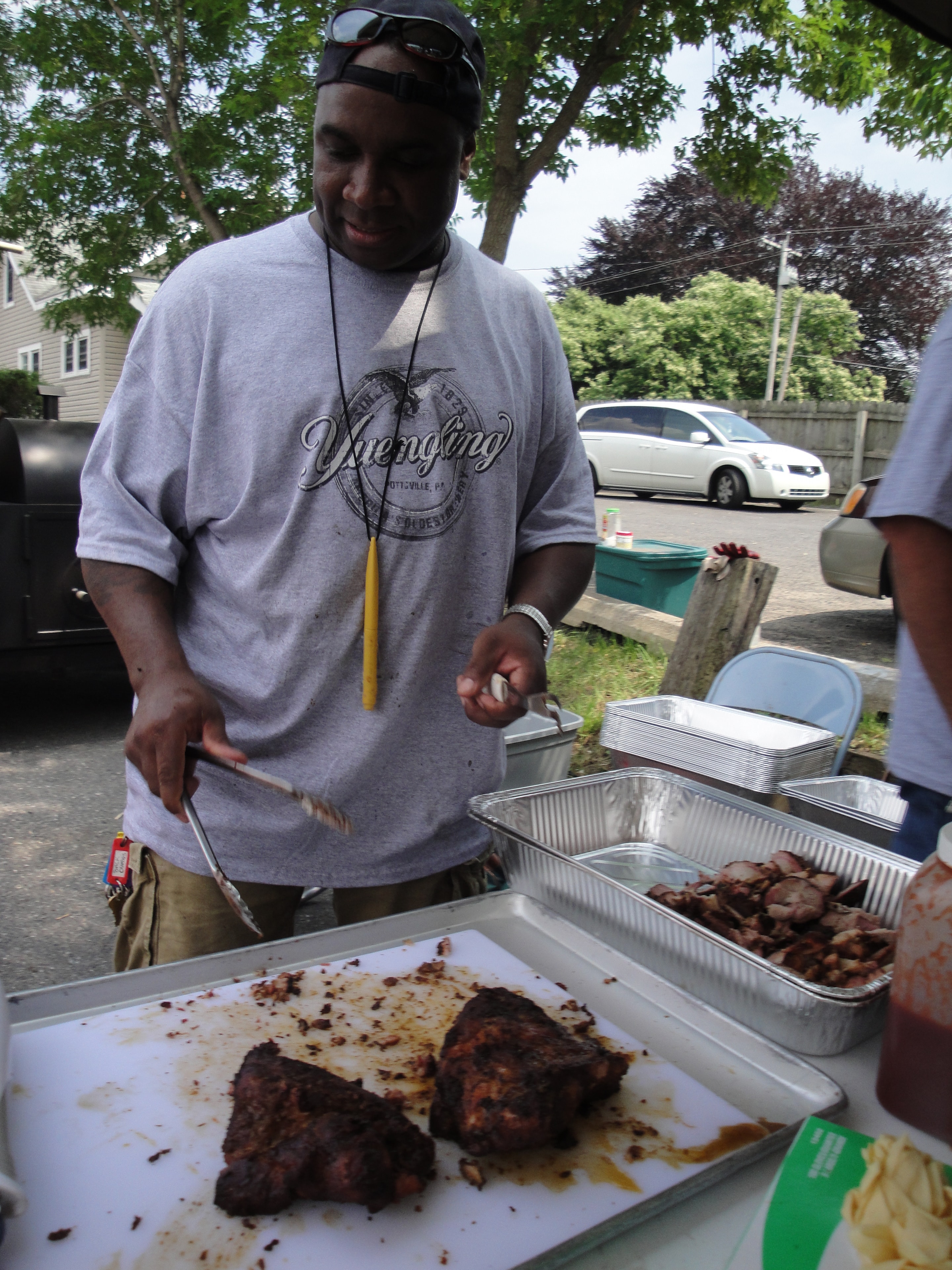 Higie's Iron Horse Saloon Summer BBQ Series — man grilling BBQ in Yuengling shirt