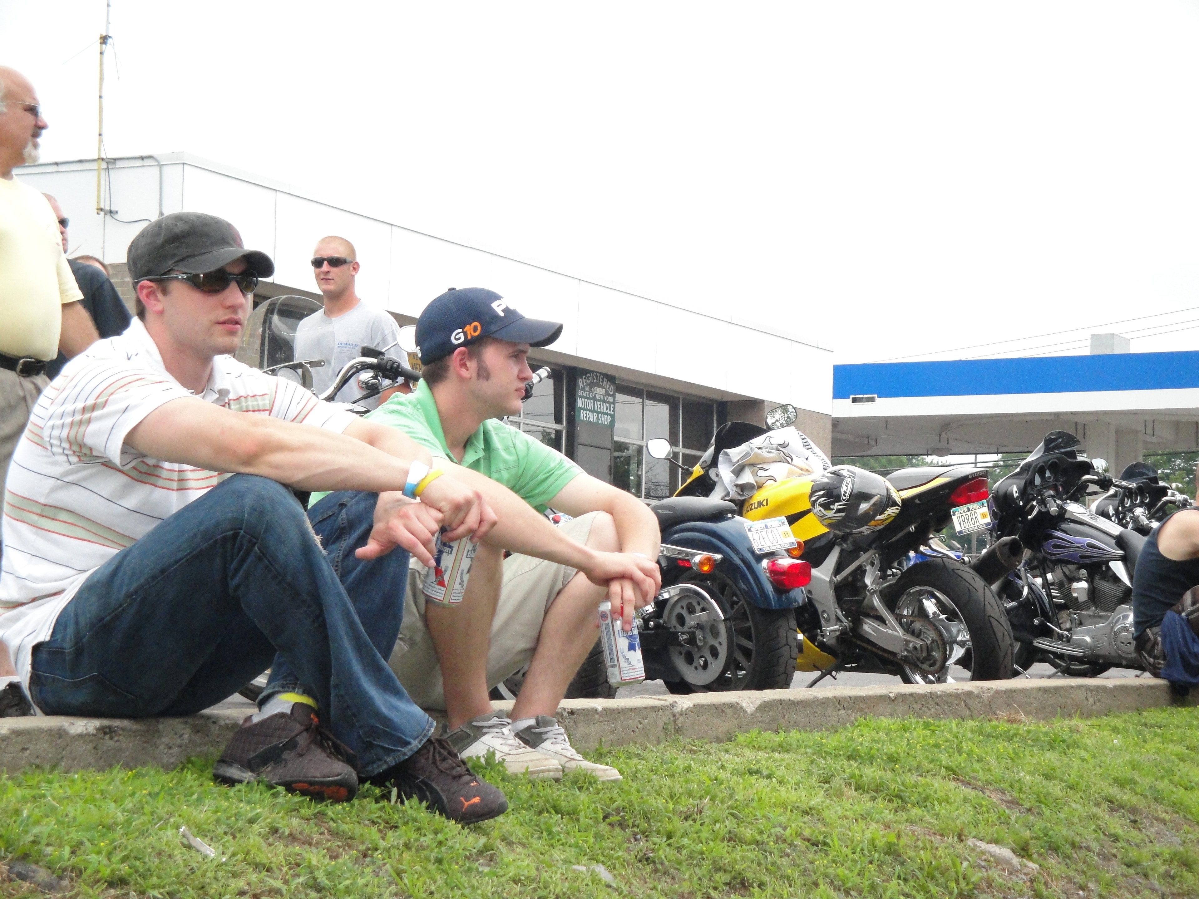 Higie's Iron Horse Saloon Summer BBQ Series — two guys sitting on curb watching the event