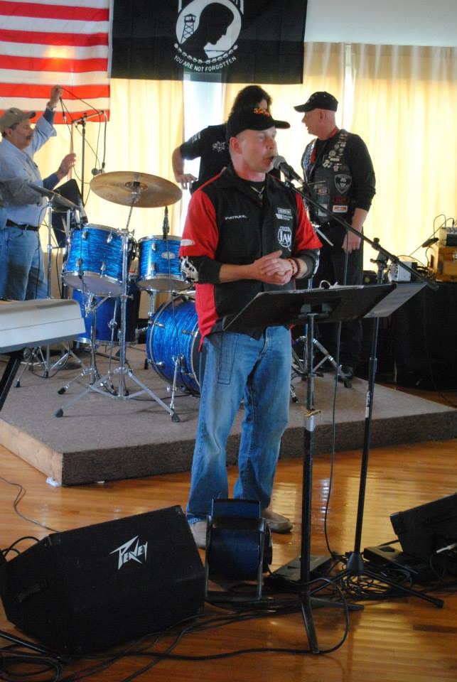Pearl Street Jam Kick-Start Party — performer on stage with POW-MIA flag