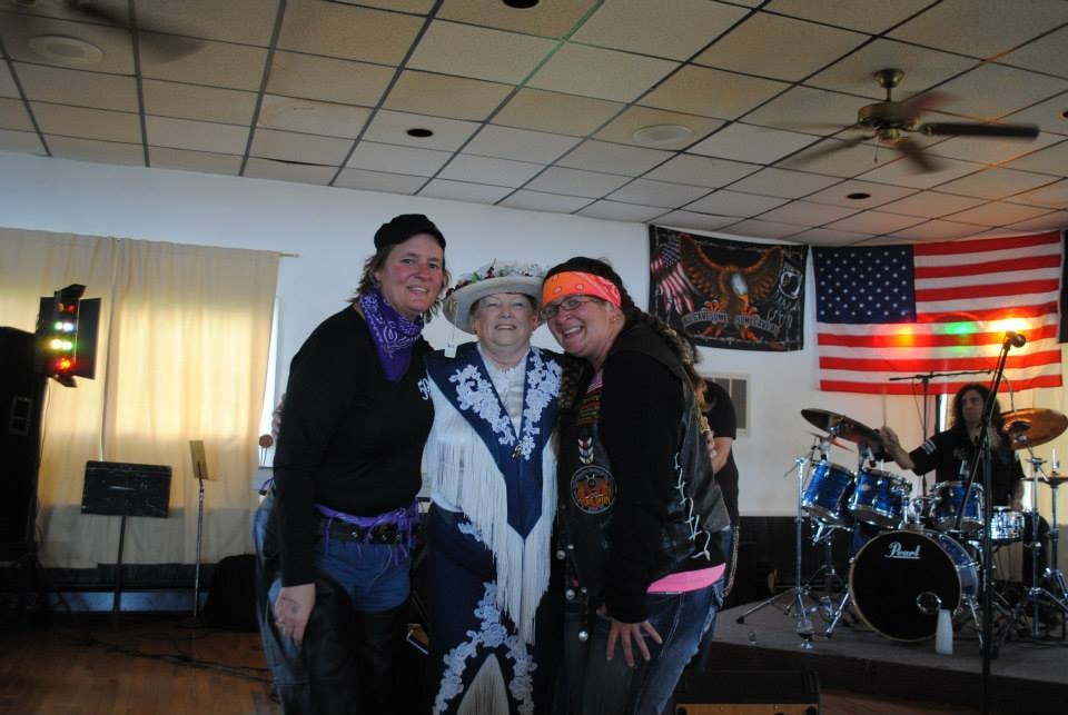 Pearl Street Jam Kick-Start Party — three women posing with band on stage