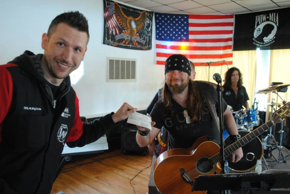 Pearl Street Jam Kick-Start Party — Marcus presenting check to guitarist on stage