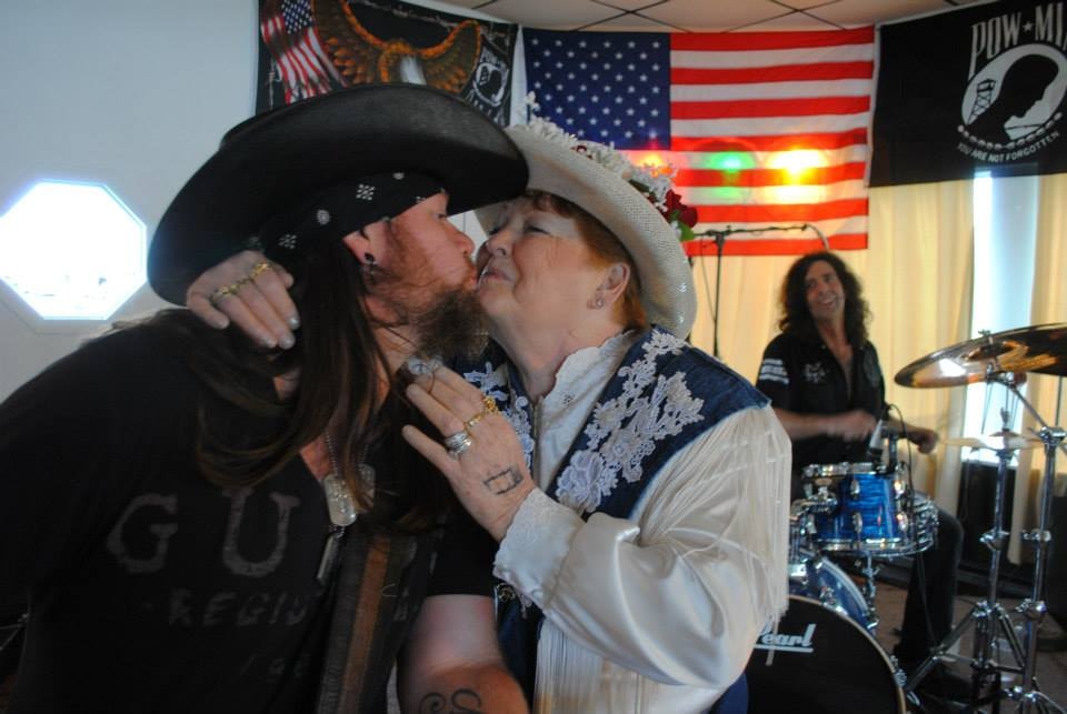 Pearl Street Jam Kick-Start Party — couple in cowboy hats kissing at event with band