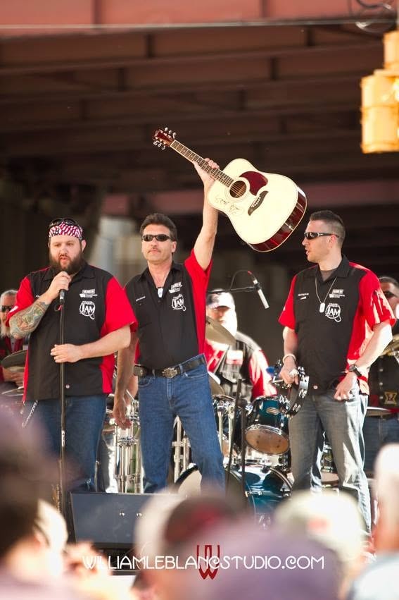 Pearl Street Jam — band members holding acoustic guitar on stage