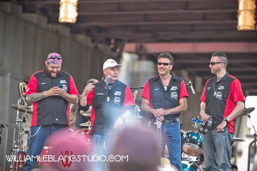 Pearl Street Jam — four crew members on stage in red and black JAM shirts