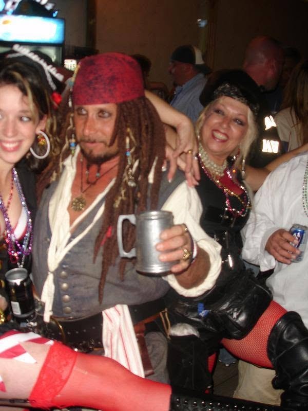 Woody's Pirate Party — Jack Sparrow lookalike with pewter mug flanked by two pirate wenches at the bar