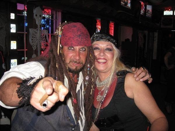 Woody's Pirate Party — Jack Sparrow lookalike pointing at camera with pirate wench inside decorated bar