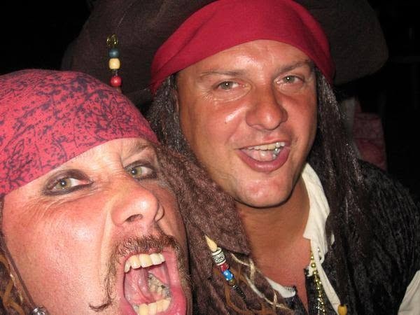 Woody's Pirate Party — two men in pirate costumes mugging for the camera outdoors at night