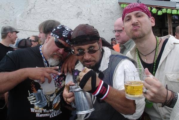 Woody's Pirate Party — three men in pirate gear holding pewter mugs and beer outside the venue