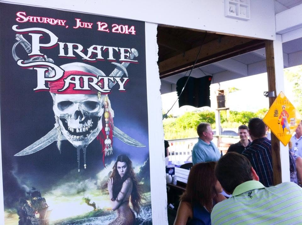 Woody's Pirate Party — July 12 2014 event poster on display at venue entrance with guests arriving