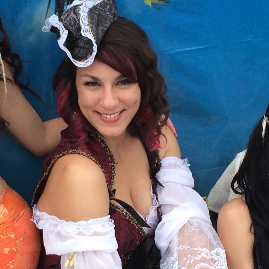 Woody's Pirate Party — pirate wench with mini lace hat and red highlights smiling at tropical backdrop