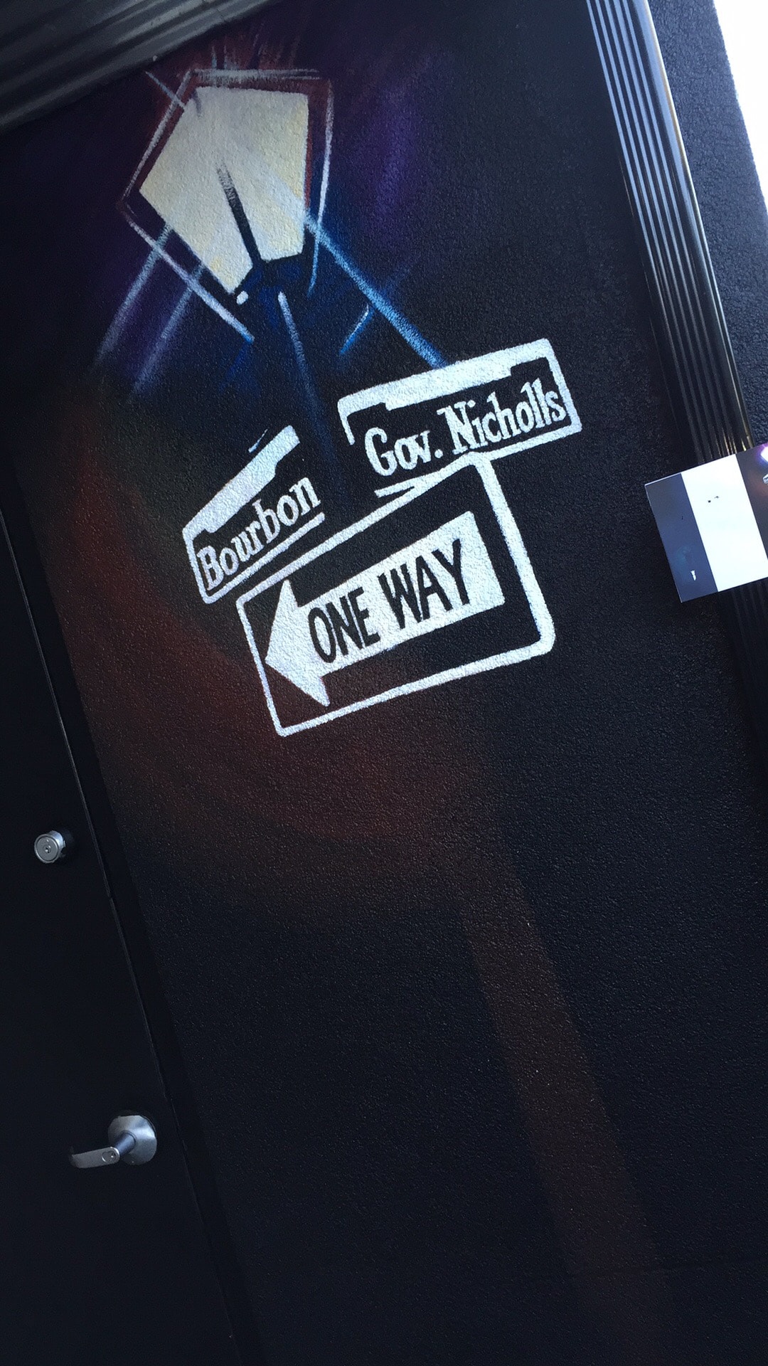 Bourbon St / Gov. Nicholls / One Way street sign on door