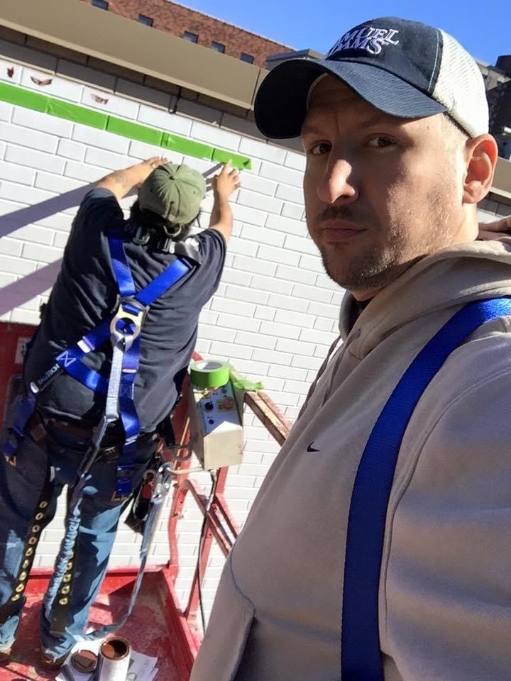 Marcus Osmun and crew beginning work on the mural — early border and green base coat application