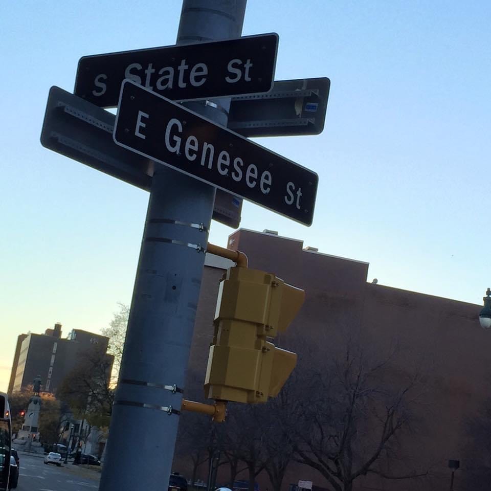 S State St and E Genesee St intersection street signs — the corner where the mural is located