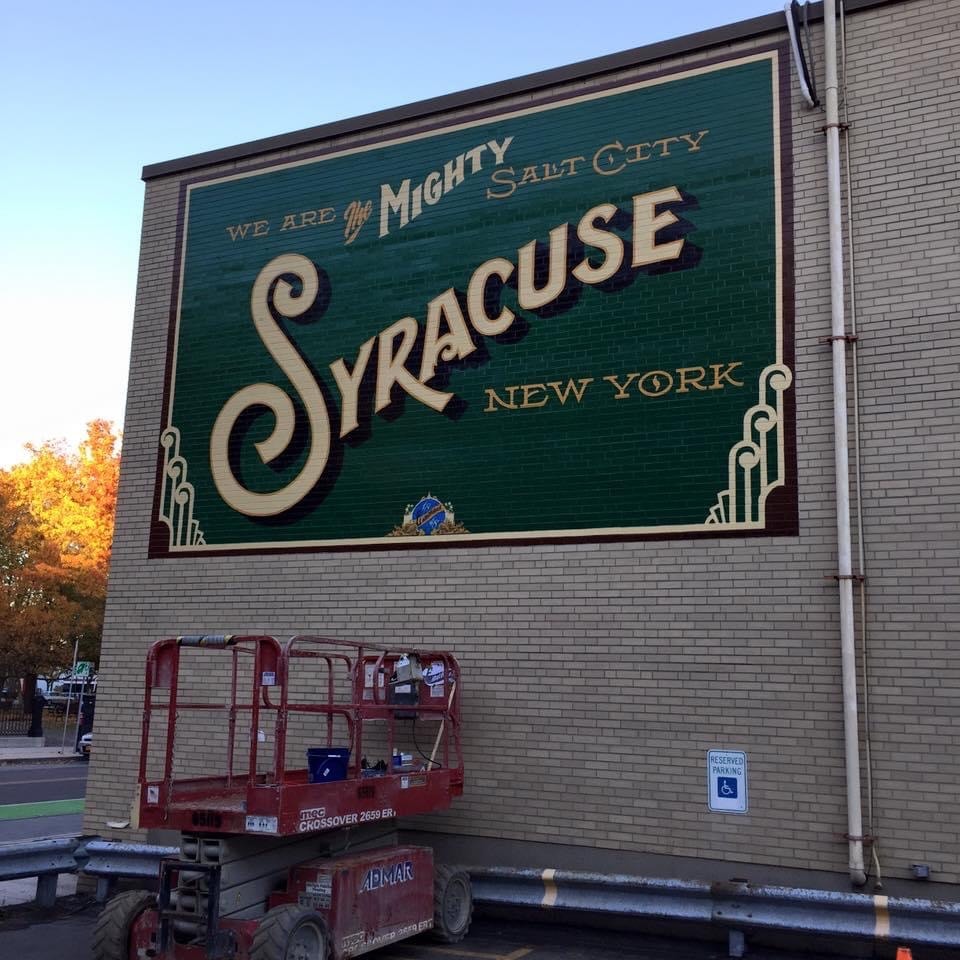 Completed mural at dusk, full view with scissor lift still parked below