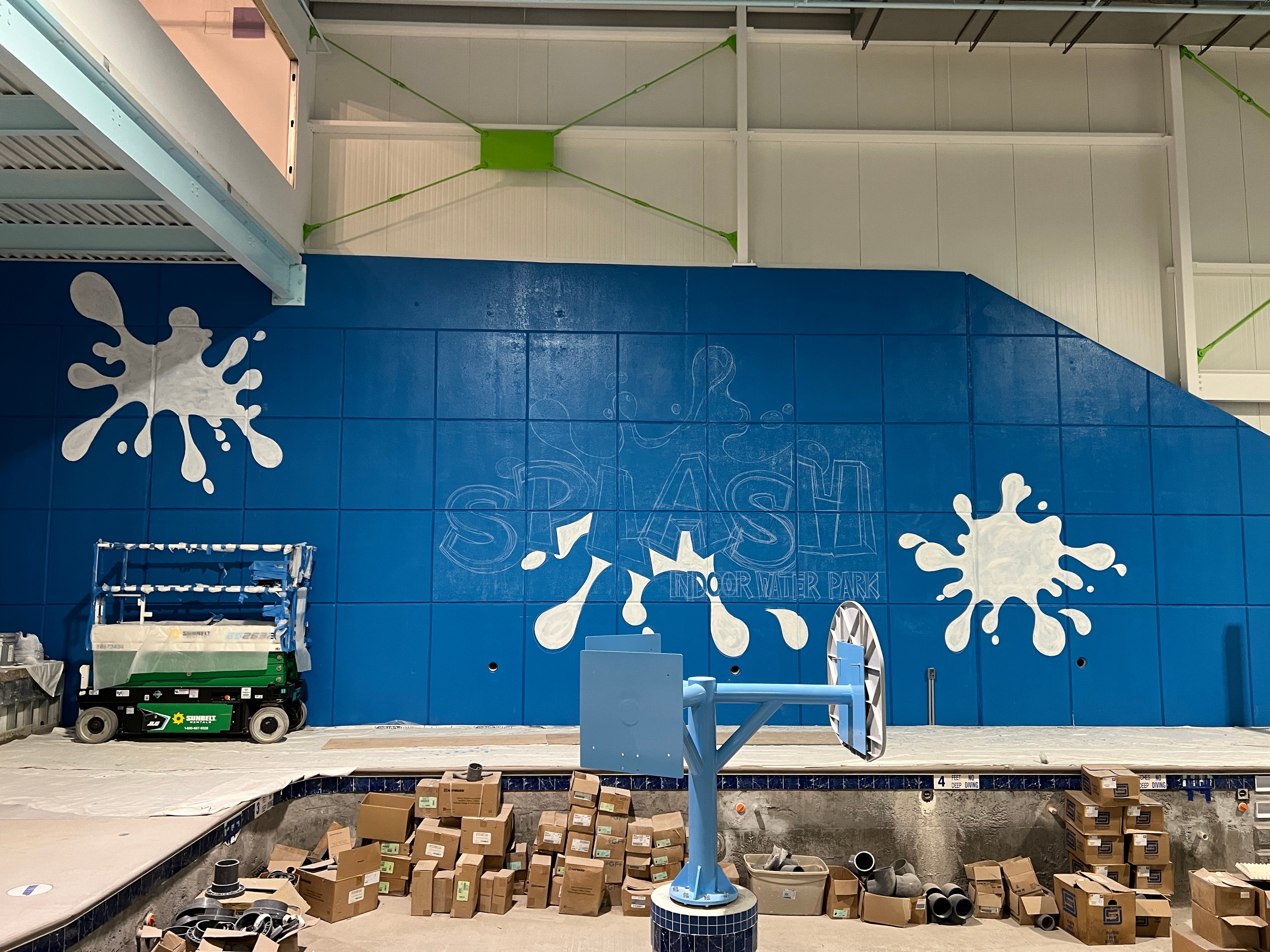 Overhead view of the blue tile wall with white splash graphics and green accents taking shape