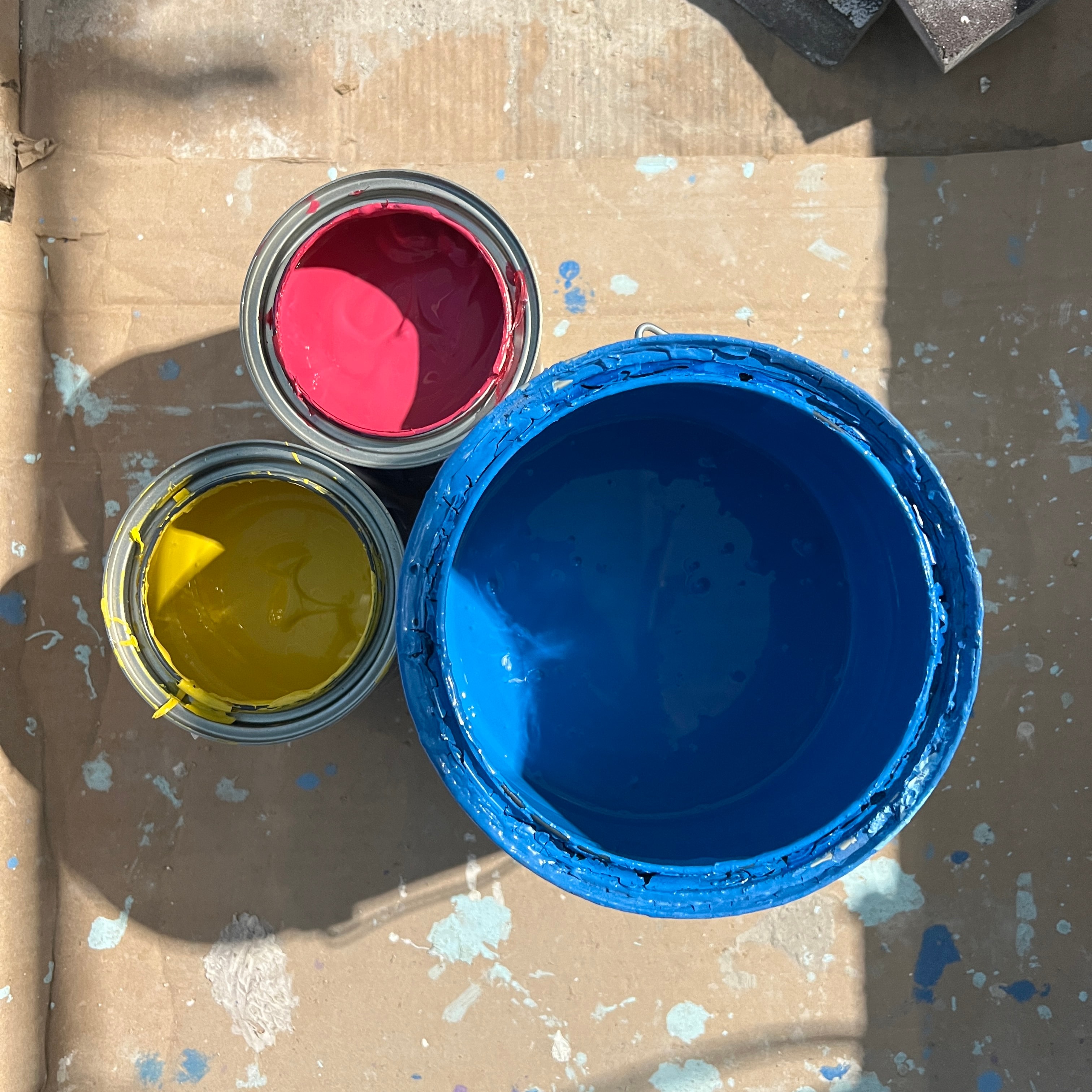 Paint cans used for the Splash mural — red, yellow, and blue acrylic waterproof formulation