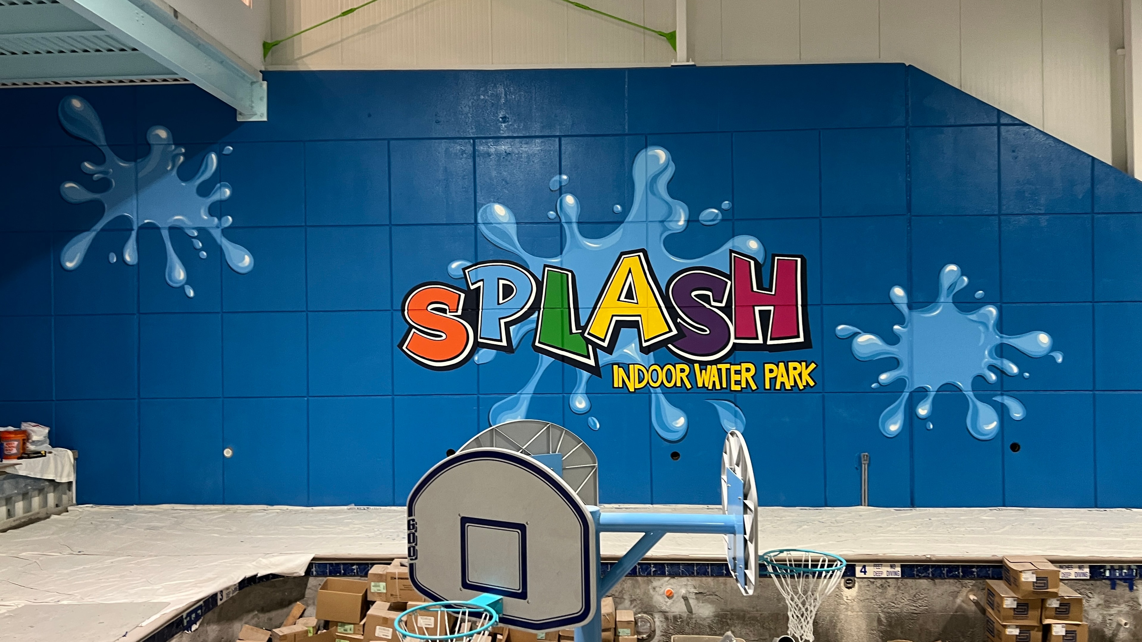 Wide view of the completed SPLASH mural showing the full angled wall surface