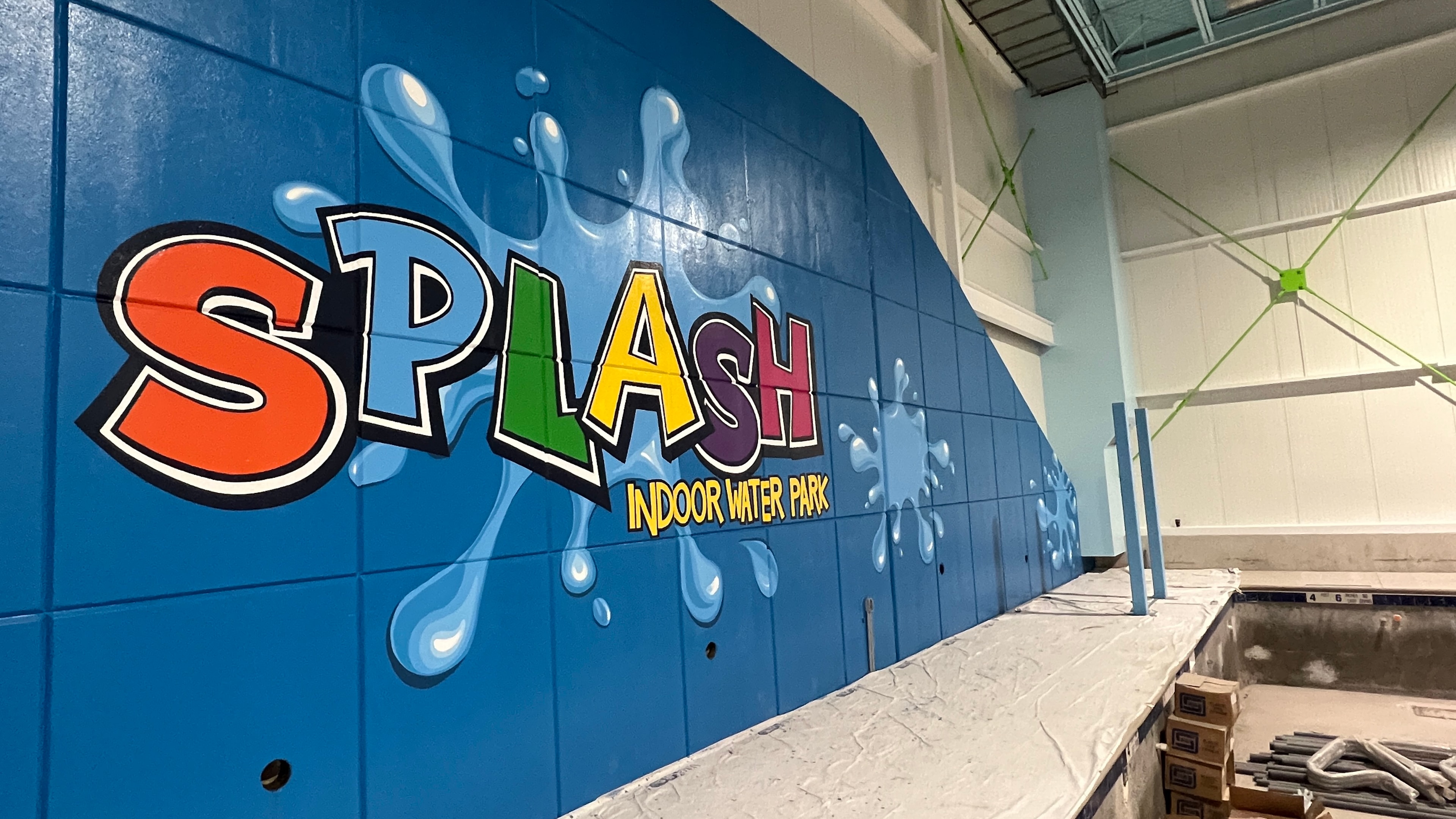 Close-up of the completed SPLASH lettering — bold multi-color letters with black outlines on blue tile wall