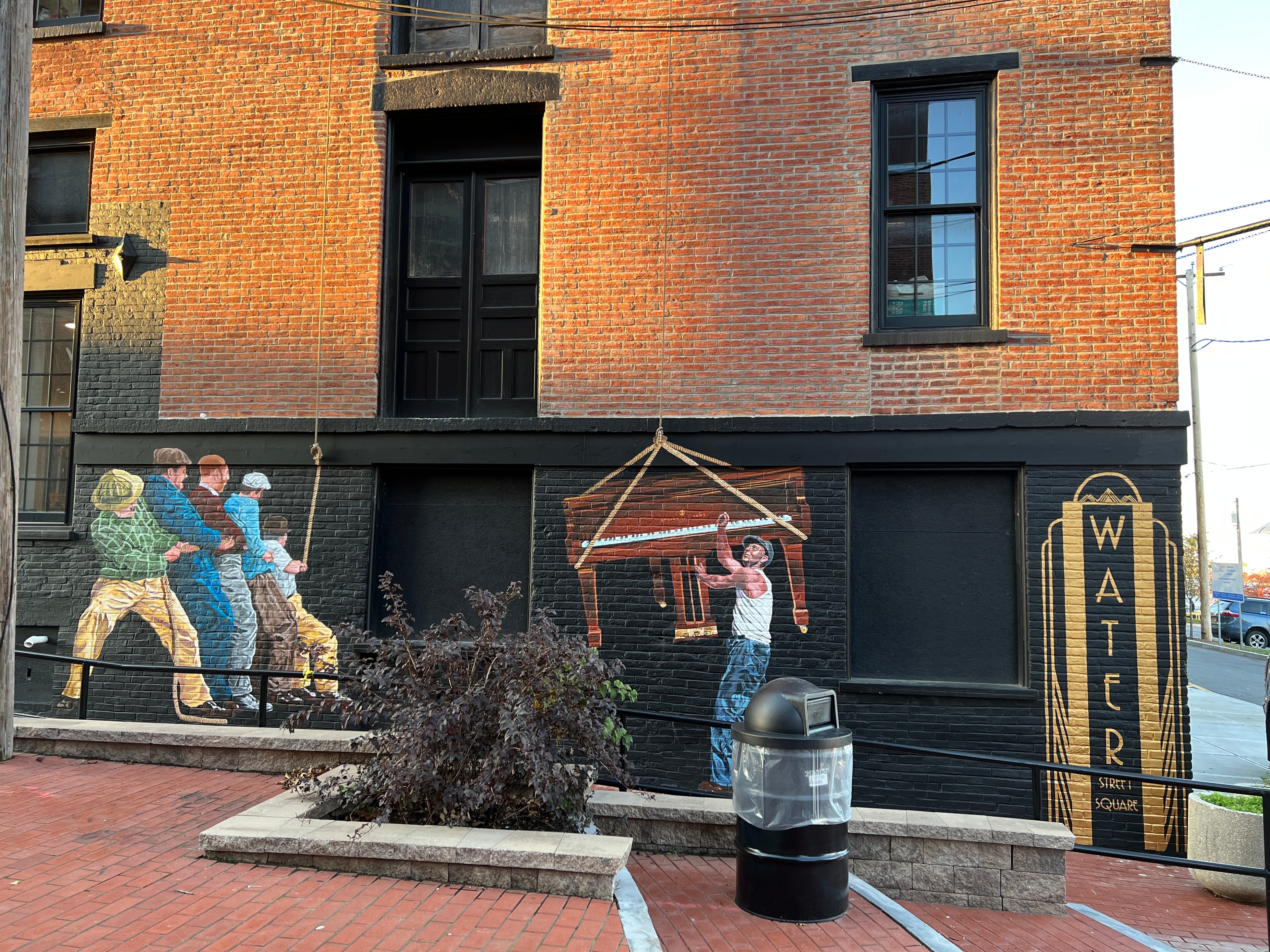Piano crew and Water Street Square art deco sign — exterior street view